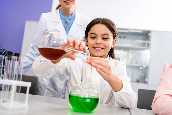 Lächelndes Schulmädchen Mit Bechern Beim Chemischen Experiment Während Des Chemieunterrichts — Stockfoto