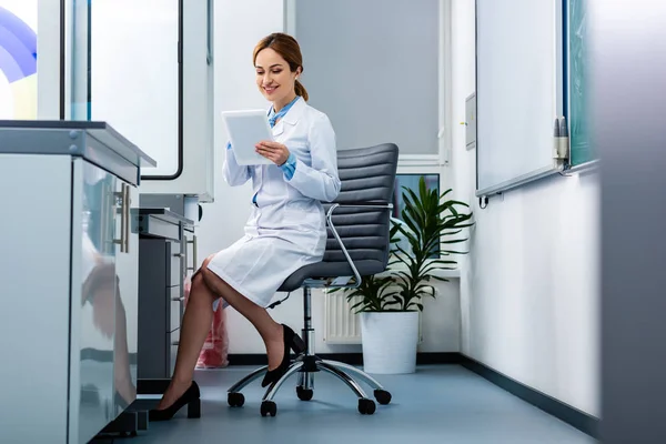 Professora Química Sorridente Casaco Branco Usando Tablet Digital Enquanto Sentada — Fotografia de Stock