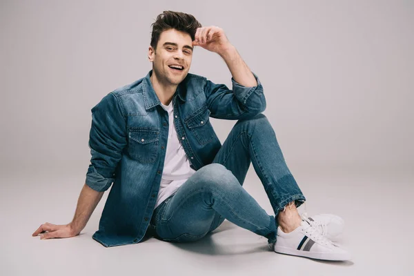 Lächelnder Mann Jeans Rock Und Shirt Mit Überkreuzten Beinen Sitzt — Stockfoto