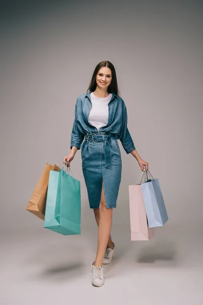 Lachende Mooie Vrouw Denim Jurk Boodschappentassen Houden Kijken Naar Camera — Stockfoto