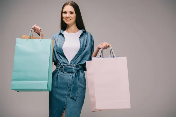 Mujer Sonriente Hermosa Vestido Mezclilla Sosteniendo Bolsas Compras Mirando Cámara — Foto de Stock