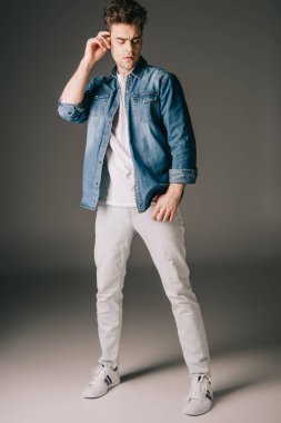 kot gömlek ve gri arka plan üzerinde seyir kot yakışıklı adam 