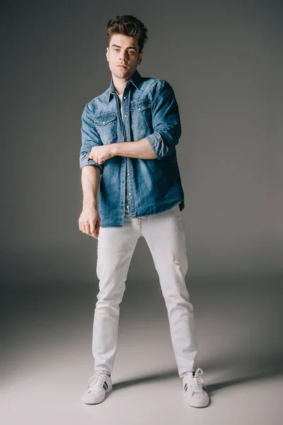 Hombre Guapo Camisa Mezclilla Jeans Mirando Cámara Sobre Fondo Gris — Foto de Stock