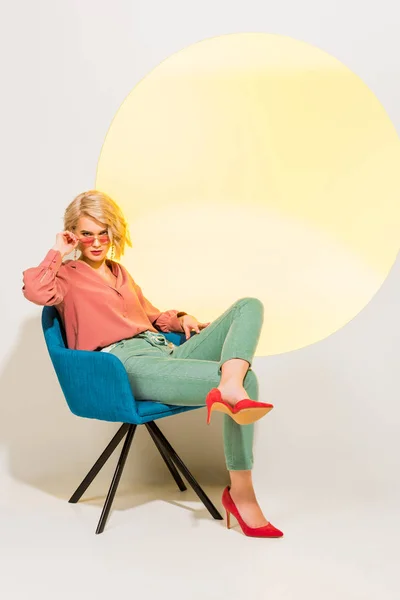 Όμορφη Κομψή Νεαρή Γυναίκα Πολύχρωμα Ρούχα Που Κάθονται Στην Πολυθρόνα — Φωτογραφία Αρχείου