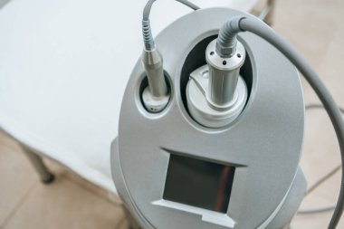 Grey  apparatus with hoses near beauty couch in clinic