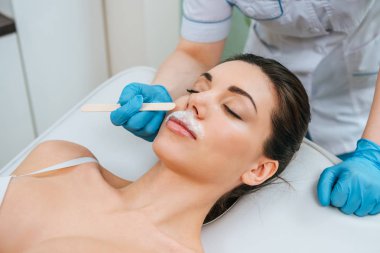 Güzellik uzmanı alkalin epilasyon yaparken lastik eldiven kısmi görünümünü