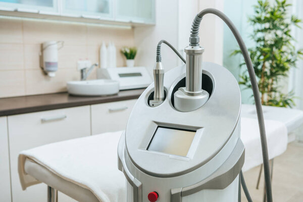 Grey  apparatus with hoses near beauty couch in clinic