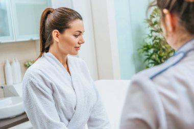 Güzellik Kliniği beyaz bornoz güzel gülümseyen genç kadın