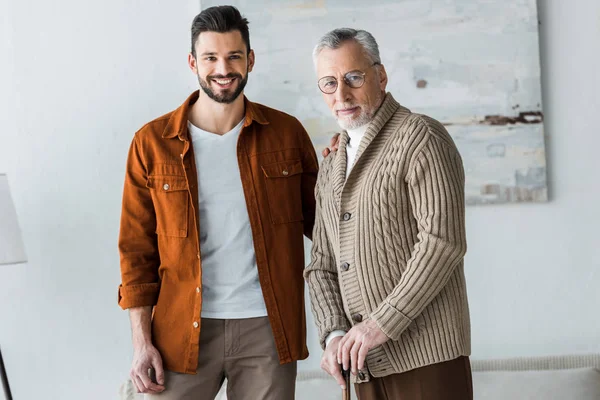 Stilig Man Ler Medan Stående Med Glada Senior Far Glas — Stockfoto