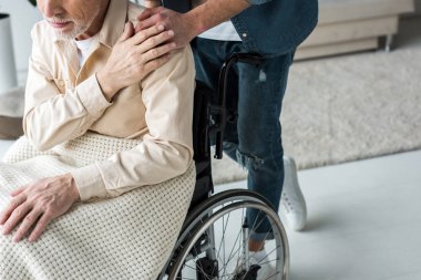 Elele Engelli kıdemli baba ile tekerlekli sandalyede evde bakım oğlu kırpılmış görünümü 