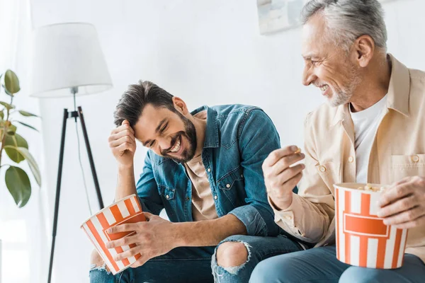 Feliz Padre Mayor Sentado Con Sonriente Hijo Sosteniendo Palomitas Maíz —  Fotos de Stock