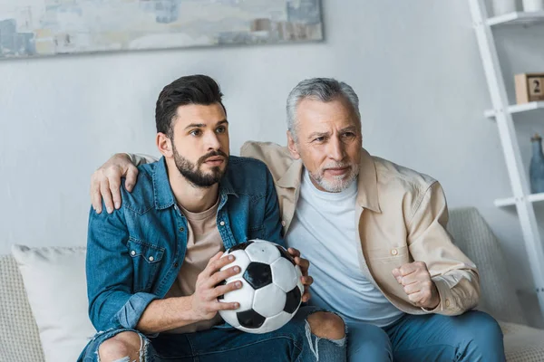 Homem Sênior Assistindo Campeonato Com Bonito Filho Segurando Futebol — Fotografia de Stock