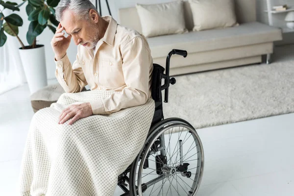 沉思的残疾老人坐在家里的轮椅上 — 图库照片