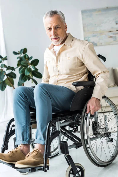 Инвалид Старший Мужчина Сидит Инвалидной Коляске Дома Смотрит Камеру — стоковое фото