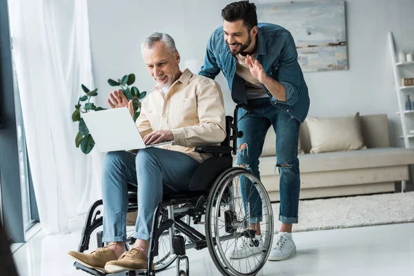 Cheerful Disabled Retired Man Sitting Wheelchair Bearded Son Waving Hand — Stock Photo, Image