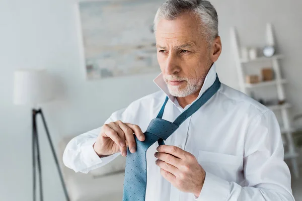 Hombre Jubilado Elegante Seguro Atando Corbata Azul Casa —  Fotos de Stock