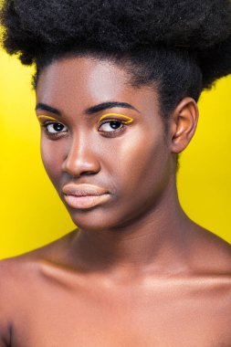 Çekici African Amerikan kadın moda makyaj görünümlü kamera izole sarı