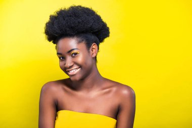 Sarı üzerinde izole makyaj ile neşeli gülümseyen Afrikalı Amerikalı kız