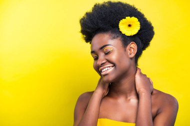 Sarı üzerinde çiçek ile neşeli gülümseyen Afrikalı Amerikalı kadın