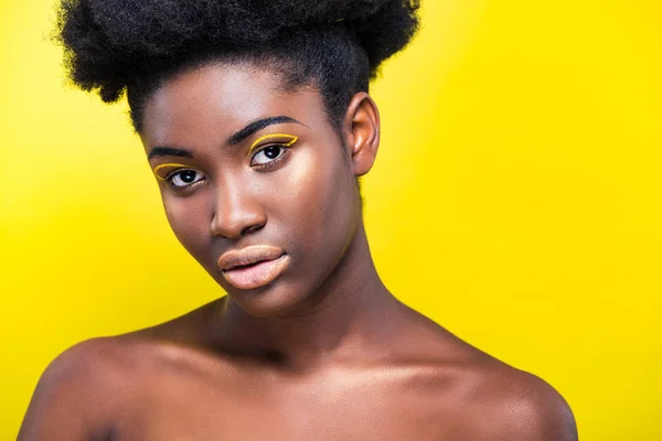 魅力的なアフリカ系アメリカ人の女性は 黄色の上に孤立したカメラを見て 流行のメイクアップ — ストック写真