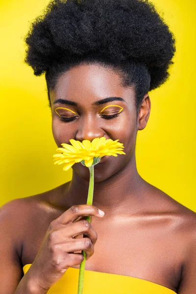 黄色に閉じた目で花を嗅ぎゴージャスなアフリカ系アメリカ人の女性 — ストック写真