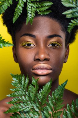 Sarı üzerinde yeşil Fern ile güzel Afrikalı Amerikalı kadının ön görünümü