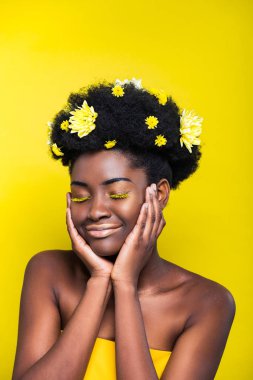 Sarı üzerinde izole kapalı gözleri ile saç krizsanthemums ile rahat Afrikalı Amerikalı kız