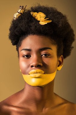 kahverengi üzerinde kelebekler ve sarı vücut sanatı ile güzel Afrikalı Amerikalı kadın