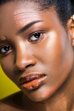 Üzgün African Amerikan Genç kadın seyir içinde kamera üzerinde sarı
