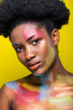 Sarı üzerinde izole kamera görünümlü vücut sanatı ile Afrikalı Amerikalı kadın