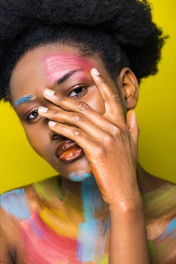 Güzel African Amerikan kadın ile vücut Sanat dokunmadan yüz izole üzerinde sarı