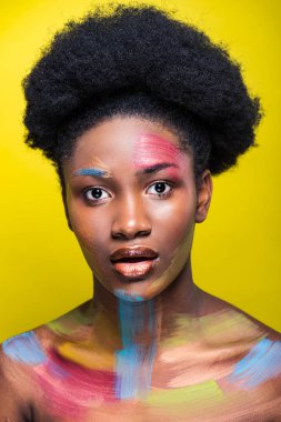 Sarı üzerinde izole kamera bakarak parlak makyaj ile sürpriz Afrikalı Amerikalı kız