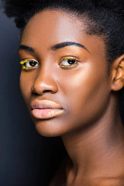 黒い上のカメラを見て黄色のまつげと美しいアフリカ系アメリカ人の女性 — ストック写真