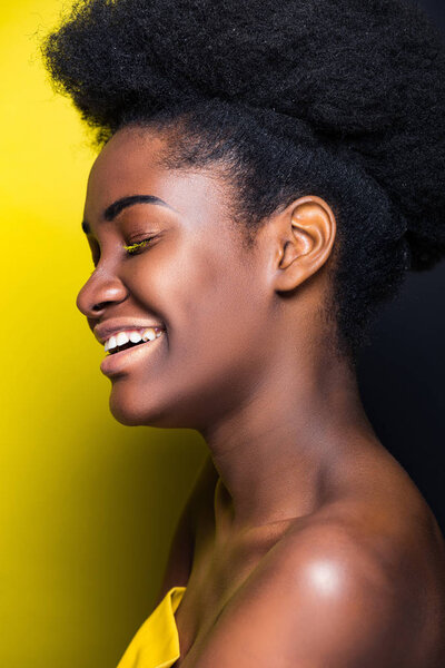Happy african american girl smiling on black and yellow