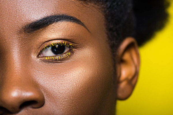 Cropped view of beautiful african american looking at camera on yellow