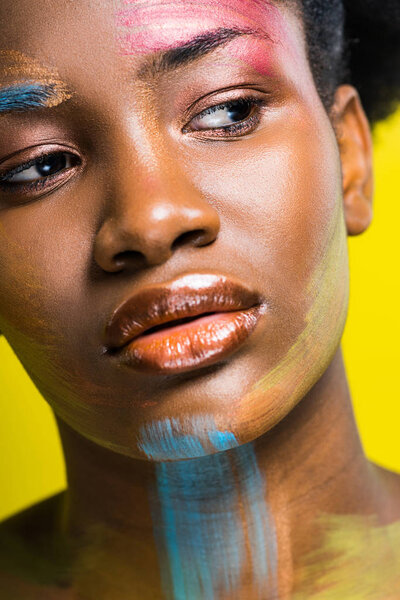 Cropped view of beautiful african american woman with body art isolated on yellow