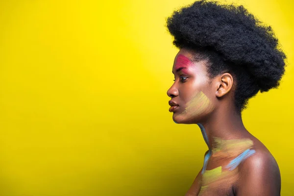 Side view of beautiful african american woman on yellow