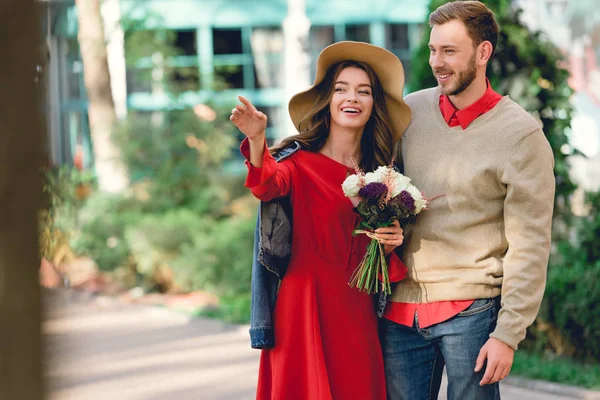 Homem Bonito Com Namorada Atraente Chapéu Segurando Flores Apontando Com — Fotografia de Stock