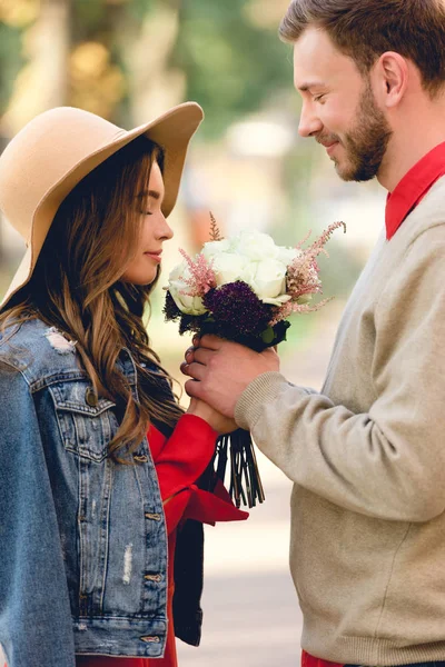 Handsome Man Looking Attractive Girlfriend Hat Smelling Flowers — Stock Photo, Image