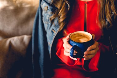 kafede kahve tutan genç kadın kırpılmış görünümü 