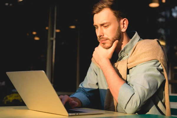 Zamyślony Brodaty Freelancer Przy Użyciu Laptopa Podczas Pracy Kawiarni — Zdjęcie stockowe