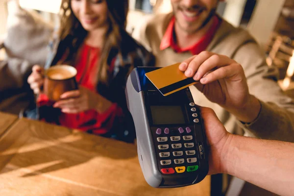 裁剪的人拿着信用卡 而支付在咖啡馆 — 图库照片
