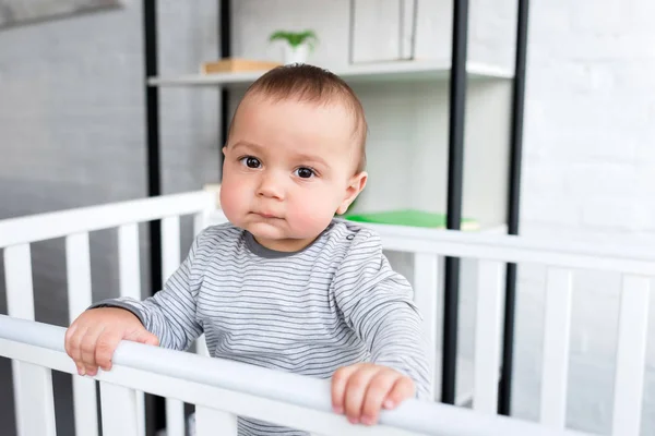 Primer plano retrato de lindo niño en cuna mirando a la cámara - foto de stock