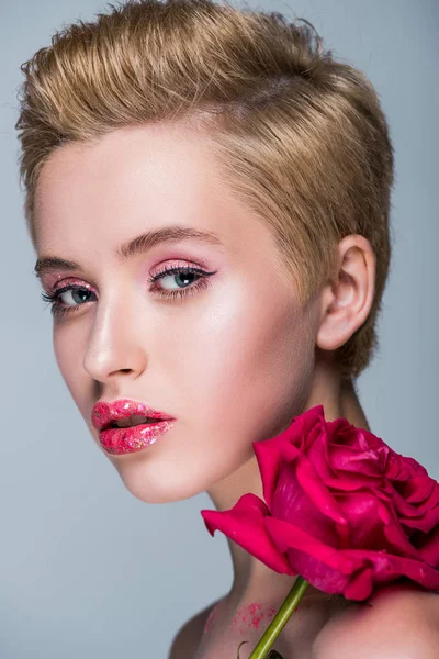 Portrait de femme séduisante avec des paillettes sur les lèvres et rose rouge isolé sur gris — Photo de stock