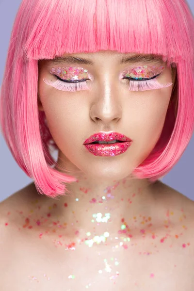 Mulher atraente com cabelo rosa, pestanas rosa e maquiagem brilhante isolado em violeta — Fotografia de Stock