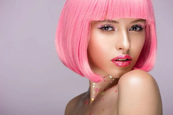 Приваблива жінка позує з рожевим волоссям і блищить на обличчі ізольована на фіолетовому — стокове фото