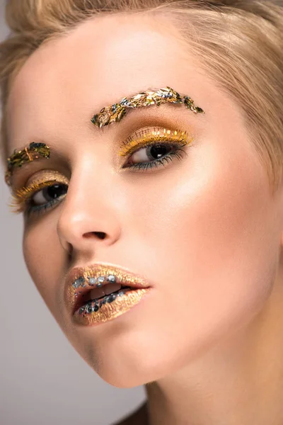 Kopfschuss einer attraktiven Frau mit glitzerndem Make-up, die in die Kamera schaut — Stockfoto