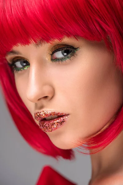 Foto de la mujer atractiva con el pelo rojo y brillo en la cara mirando a la cámara - foto de stock