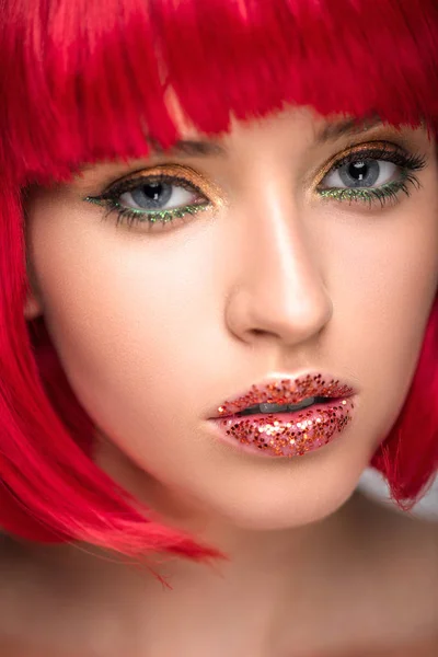 Foto de la mujer atractiva con el pelo rojo y maquillaje brillante mirando a la cámara - foto de stock