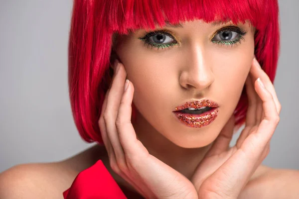 Привлекательная женщина с рыжими волосами и блестящим макияжем трогательное лицо, изолированное на сером — стоковое фото